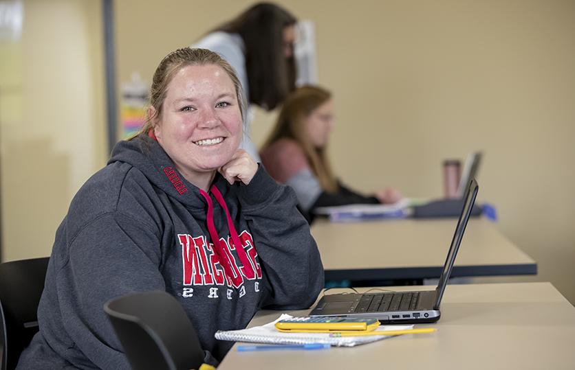 female student smiling at desk